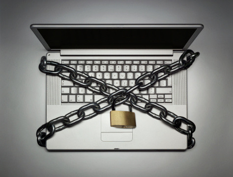 Laptop locked with chain, close-up, overhead view, (digital composite)