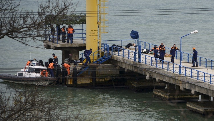Russian rescue workers carry a body from the wreckage of the crashed plane, at a pier just outside Sochi, Russia, Sunday, Dec. 25, 2016. Russian ships, helicopters and drones are searching for bodies after a plane carrying 93 people crashed into the Black Sea. The plane was taking the Alexandrov Ensemble, a military choir, to perform at Russia's air base in Syria when it went down shortly after takeoff. (AP Photo/Viktor Klyushin)