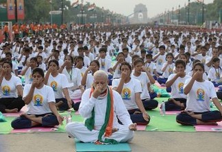 Indian Prime Minister Narendra Modi (C) participates in a mass yoga session along with other Indian yoga practitioners to mark the International Yoga Day on Rajpath in New Delhi on June 21, 2015.  Prime Minister Narendra Modi on June 21 hailed the first International Yoga Day as a "new era of peace", moments before he took to a mat and joined thousands in the heart of New Delhi to celebrate the ancient Indian practice.  AFP PHOTO / PRAKASH SINGH (Photo by PRAKASH SINGH / AFP)