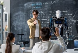 Contemporary teacher pointing at one of students wanting to ask question about characteristics of robot standing by blackboard