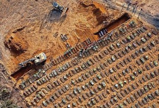 Aerial view of coffins being buried at an area where new graves have been dug at the Parque Taruma cemetery, during the COVID-19 coronavirus pandemic in Manaus, Amazonas state, Brazil, on April 21, 2020. - Graves are being dug at a new area of the cemetery for suspected and confirmed victims of the COVID-19 coronavirus pandemic. (Photo by MICHAEL DANTAS / AFP)