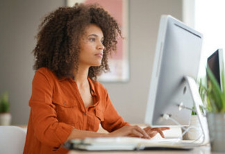 Cheerful businesswoman working on desktop computer