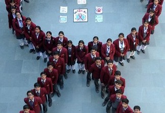 Indian school students pose for a photograph in the shape of a ribbon during an awareness campaign to mark World AIDS Day at a school in Amritsar on December 1, 2014. The UNAIDS agency says some 2.5 million Indians are living with HIV, many of them ostracised by their communities. AFP PHOTO/NARINDER NANU