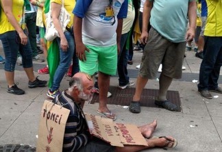 Manifestantes da Avenida Paulista vestem mendigo com os dizeres 'era empresário, virei mendigo'