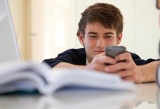 teenage school boy reading a text alert