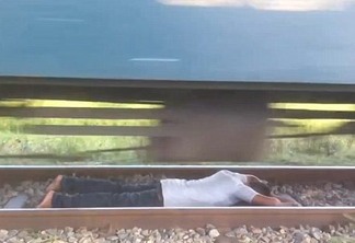 Homem arrisca a vida e fica deitado em trilhos durante passagem de trem - VEJA VÍDEO
