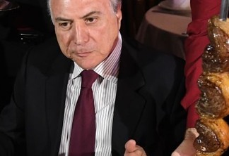 Brazilian President Michel Temer eats barbecue in a steak house in Brasilia after meeting with ambassadors from countries that import Brazilian meat, on March 19, 2017. 
The revelation on Friday of a two-year police probe into alleged bribery of health inspectors to certify tainted food as fit for consumption has struck at the heart of the world's leading exporter of beef and chicken.  / AFP PHOTO / EVARISTO SA
