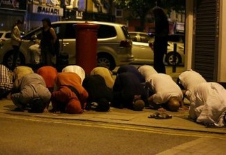Muslims pray on a sidewalk in the Finsbury Park area of north London after a vehichle hit pedestrians, on June 19, 2017. 
One person has been arrested after a vehicle hit pedestrians in north London, injuring several people, police said Monday, as Muslim leaders said worshippers were mown down after leaving a mosque. / AFP PHOTO / Daniel LEAL-OLIVAS
