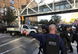 In this photo provided by the New York City Police Department, officers respond to a report of gunfire along West Street near the pedestrian bridge at Stuyvesant High School in lower Manhattan in New York, Tuesday, Oct. 31, 2017. (Martin Speechley/NYPD via AP)