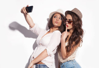 two young women taking selfie with mobile phone