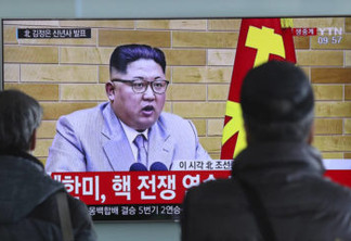 South Koreans watch a TV news program showing North Korean leader Kim Jong Un's New Year's address, at the Seoul Railway Station in Seoul, South Korea, Monday, Jan. 1, 2018. The part of letters on the bottom "South Korea and U.S., Nuclear War exercise." and on top left, "Kim Jong Un delivers New Year's address."  North Korean leader Kim Jong Un said Monday, Jan. 1, 2018,  the United States should be aware that his country's nuclear forces are now a reality, not a threat. But he also struck a conciliatory tone in his New Year's address, wishing success for the Winter Olympics set to begin in the South in February and suggesting the North may send a delegation to participate.(AP Photo/Lee Jin-man)