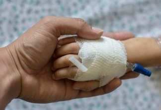 Children patient's hand recieving iv saline solution in hostpital.