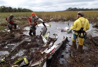 Rescue workers search the crash site of a twin-engine Beechcraft Baron in Ayolas, Paraguay, Thursday, July 26, 2018. Paraguay's agriculture minister and three other people have died in the crash of the small plane, that went down in a marshy area shortly after taking off Wednesday night from the airport in Ayolas. (Photo by Roque Gonzalez Vera/ABC Color via AP)