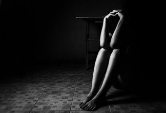 a woman sitting on ground with arm around lower head, sexual violence , sexual abuse, human trafficking concept with shadow edge in white tone