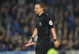 Referee Kevin Friend removes on object which was thrown onto the pitch  during the English Premier League football match between Brighton and Hove Albion and West Ham at the American Express Community Stadium in Brighton, southern England on October 5, 2018. (Photo by Glyn KIRK / AFP) / RESTRICTED TO EDITORIAL USE. No use with unauthorized audio, video, data, fixture lists, club/league logos or 'live' services. Online in-match use limited to 120 images. An additional 40 images may be used in extra time. No video emulation. Social media in-match use limited to 120 images. An additional 40 images may be used in extra time. No use in betting publications, games or single club/league/player publications. /