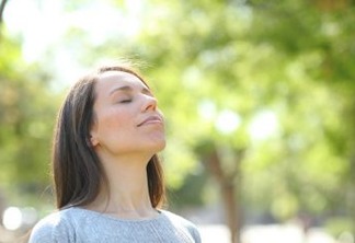 Relaxed woman breathing fresh air in a park or forest