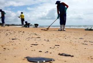 As pessoas removem um derramamento de óleo na praia de Coruripe, estado de Alagoas, Brasil, 14 de outubro de 2019. REUTERS / Adriano Machado