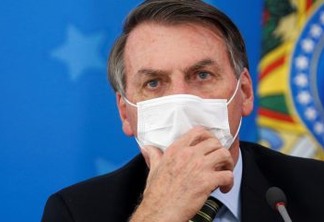 Brazil's President Jair Bolsonaro wearing a protective face masks reacts during a news conference to announce measures to curb the spread of the coronavirus disease (COVID-19) in Brasilia, Brazil March 18, 2020. REUTERS/Adriano Machado