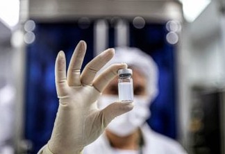 An employee holds a vial containing CoronaVac, Sinovac Biotech's vaccine against the coronavirus disease (COVID-19), at Butantan biomedical production center in Sao Paulo, Brazil January 12, 2021. REUTERS/Amanda Perobelli