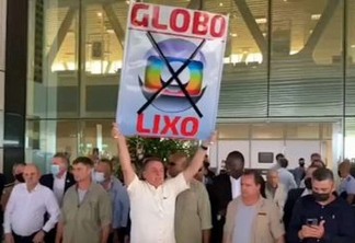 Sem máscara, Bolsonaro levanta cartaz contra a TV Globo em aeroporto - VEJA VÍDEO