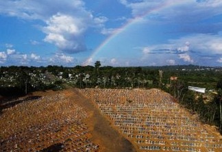 Aerial view of the burial site reserved for victims of the COVID pandemic with a rainbow in the sky at the Nossa Senhora Aparecida cemetery in Manaus, in the Amazon forest in Brazil on November 21, 2020. - Brazil has been one of the countries hit hardest by the pandemic, with more than 166,000 people killed, the second-highest number in the world, following the United States and is bracing for a possible second wave of mass infections as it races to test and then distribute its first 120,000 doses of Coronavac, a potential COVID-19 vaccine developed by Chinese lab Sinovac Biotech. (Photo by MICHAEL DANTAS / AFP)