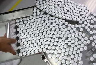 An employee puts on an equipment vials containing CoronaVac, Sinovac's vaccine against the coronavirus disease (COVID-19), at Butantan biomedical production center in Sao Paulo, Brazil January 22, 2021. REUTERS/Amanda Perobelli