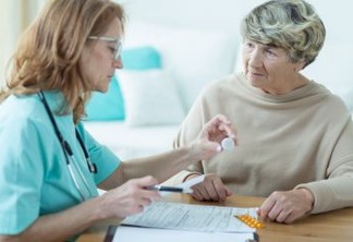 Mature physician prescribing medicament for elder woman