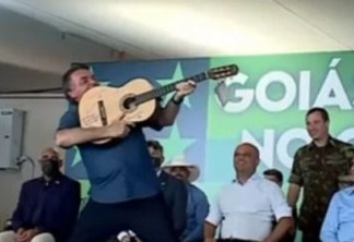 Bolsonaro é presenteado com violão autografado por sertanejos e faz gesto de arma