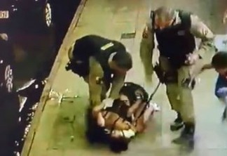 JOELHO NO PESCOÇO: Mesmo com criança de colo, mulher é imobilizada por policial militar; veja vídeo
