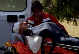 Militar ferido é transportado por socorrista após ataque à base militar em Iavoriv - Kai Pfaffenbach/Reuters