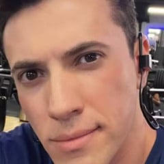 Um homem jovem está tirando uma selfie em uma academia. Ele tem cabelo escuro e usa uma camiseta azul. O fundo mostra equipamentos de musculação e outras pessoas treinando. O homem está usando um fone de ouvido.
O médico Luiz Antônio Garnica acusado de arquitetar plano com a mãe para matar a esposa - Arquivo pessoal