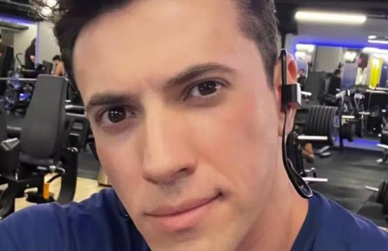 Um homem jovem está tirando uma selfie em uma academia. Ele tem cabelo escuro e usa uma camiseta azul. O fundo mostra equipamentos de musculação e outras pessoas treinando. O homem está usando um fone de ouvido.
O médico Luiz Antônio Garnica acusado de arquitetar plano com a mãe para matar a esposa - Arquivo pessoal